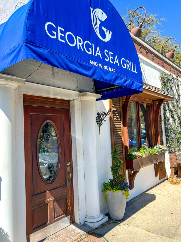 front door of restaurant with blue awning.