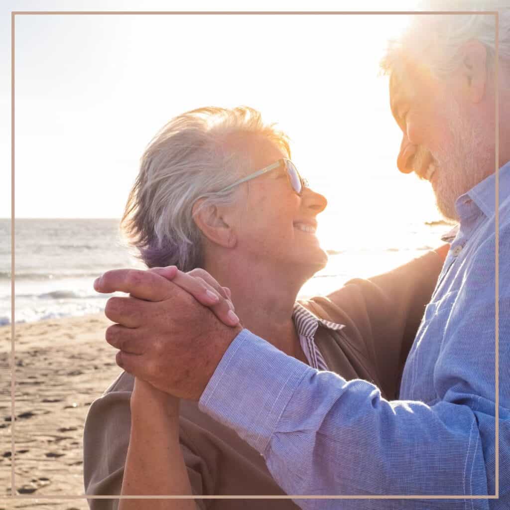 older couple dancing on the beach.