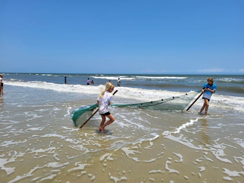 kids with seine net at beach.