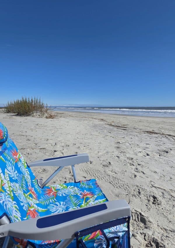 Myrtle Street Beach on St. Simons Island with a blue beach chair in the foreground.