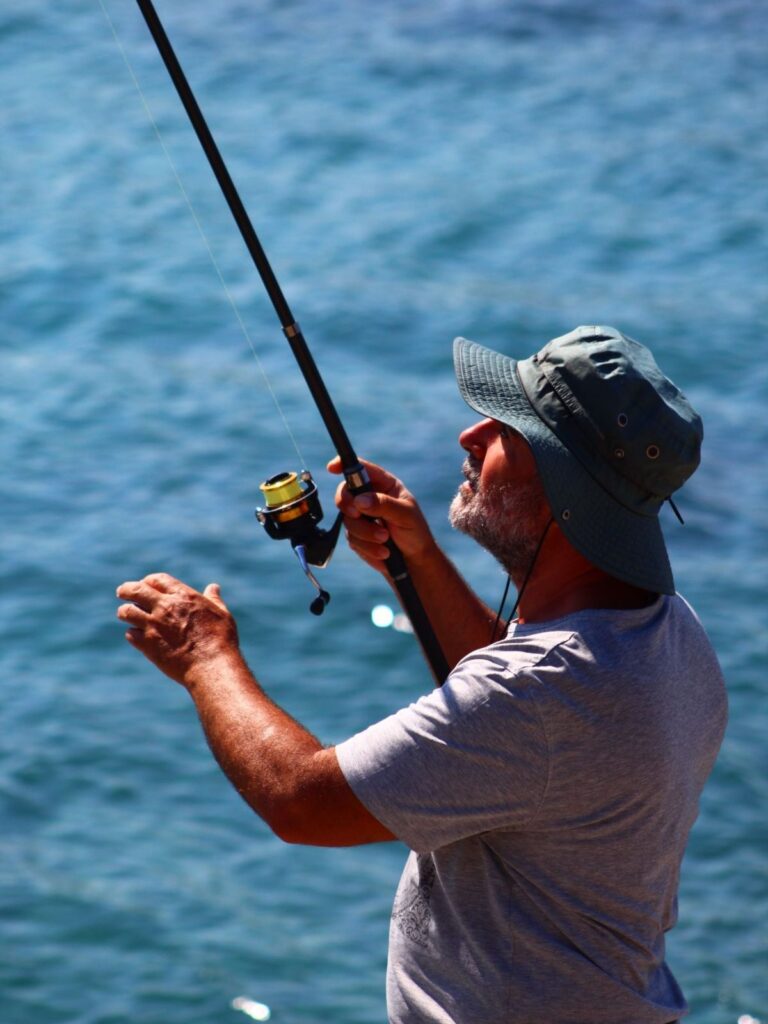 man fishing with water in background.