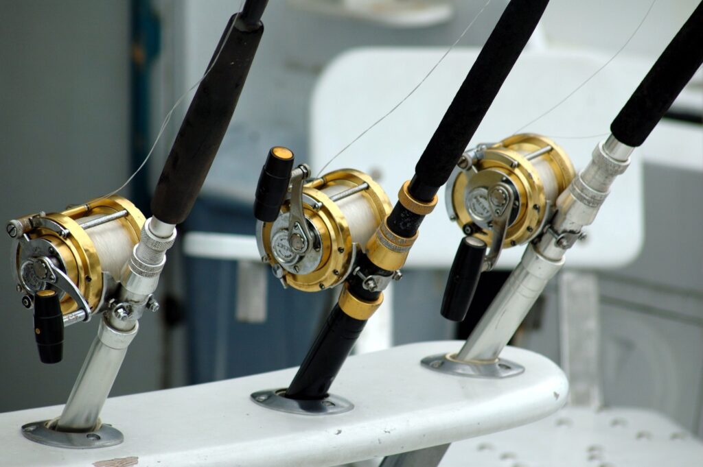 close up of 3 rod and reels on boat.